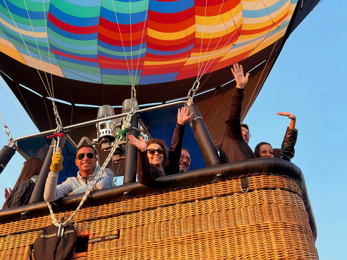 Pasajeros saludando desde la canastilla del globo