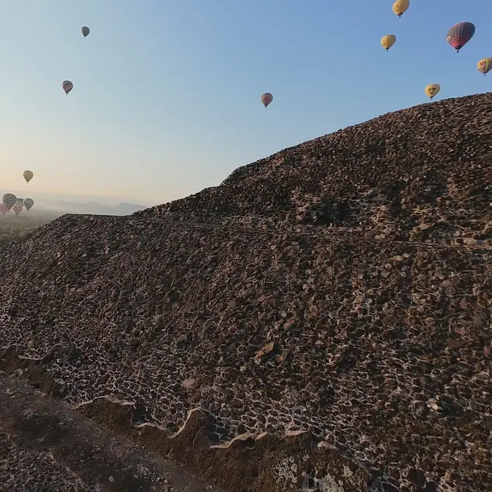 Pirámide de Teotihuacán al amanecer, con globos en el cielo